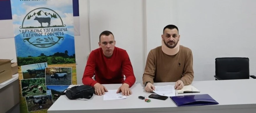 dva čovjeka sjede za stolom 