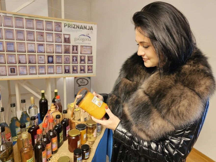 žena sa tegom meda na sajmu